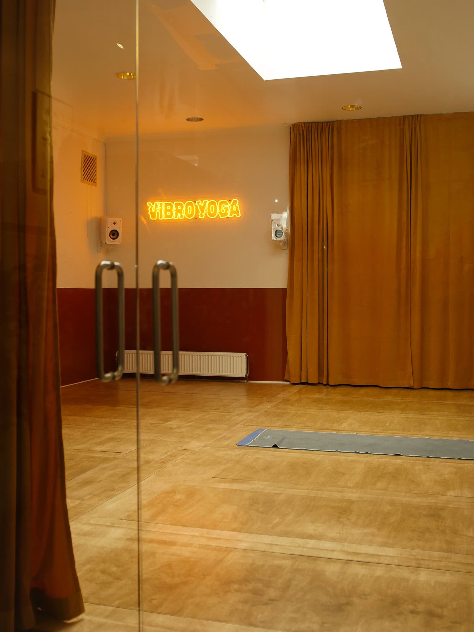 Vibro Yoga studio — warm space with neon sign and vibration platforms